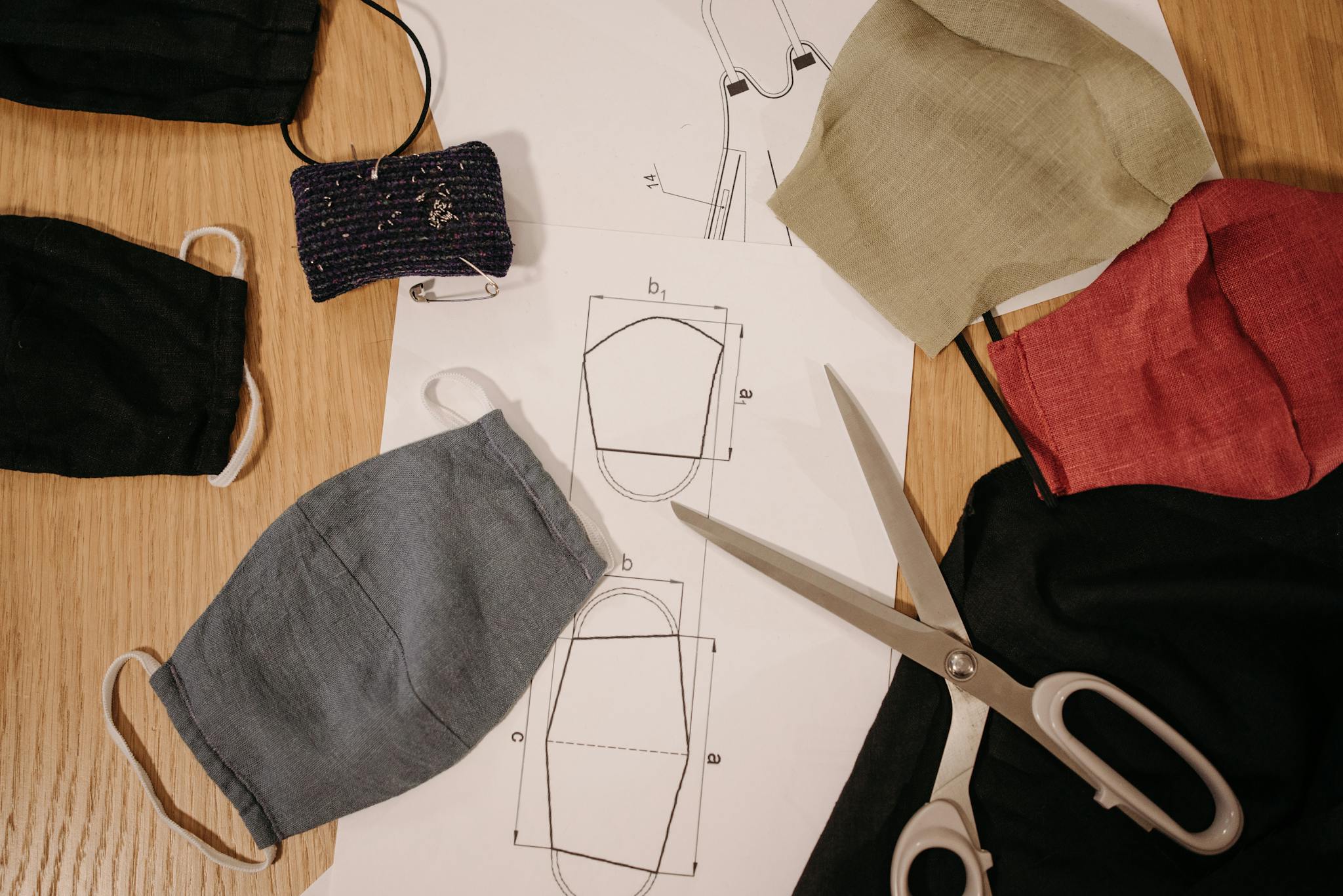 Creative setup of handmade face masks with design sketches and sewing tools.